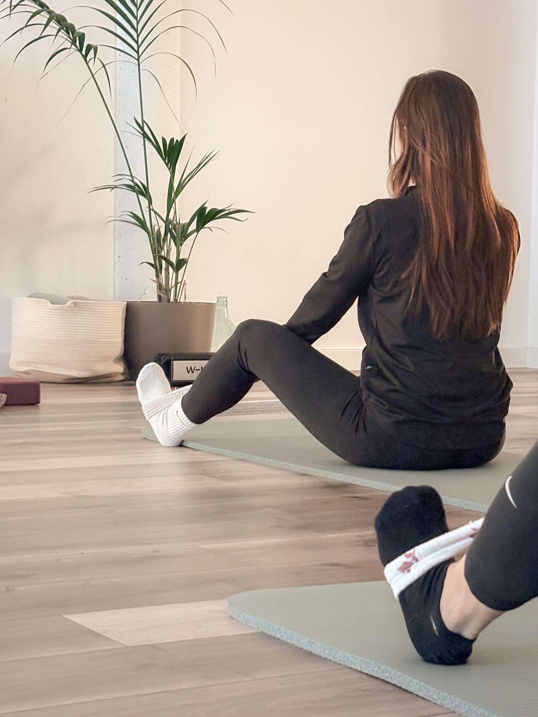 Torsione da seduta sul tappetino durante una lezione di yoga